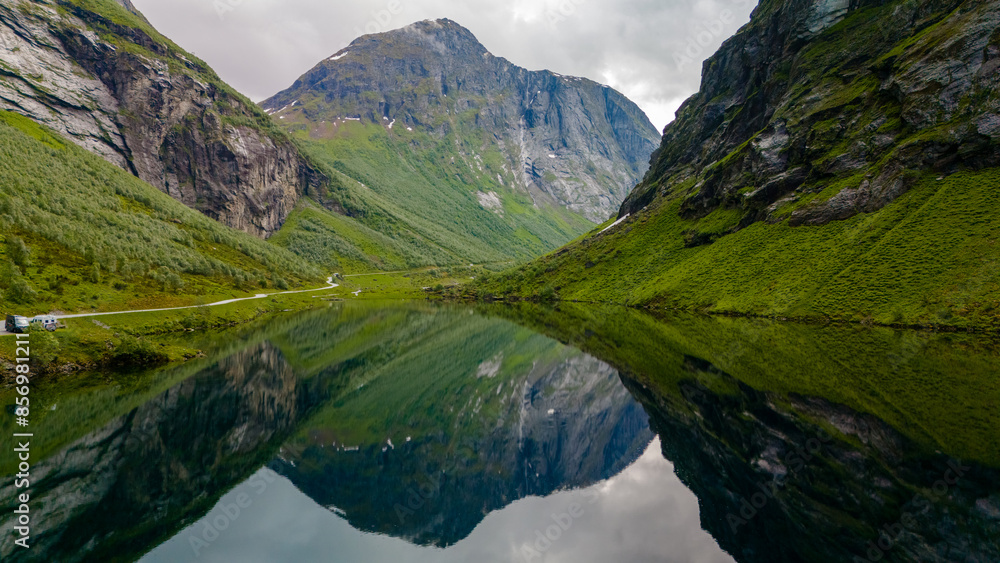 Obraz premium A serene lake nestled amidst the towering mountains of Norway, reflecting the beauty of the landscape in its still waters.