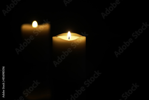 Serene Candlelight in Darkness - Two Burning Candles Isolated on Black Background