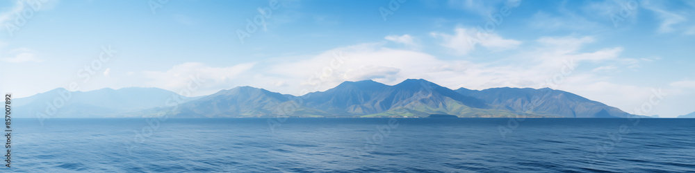 A beautiful blue ocean with mountains in the background A beautiful blue ocean with mountains in the background