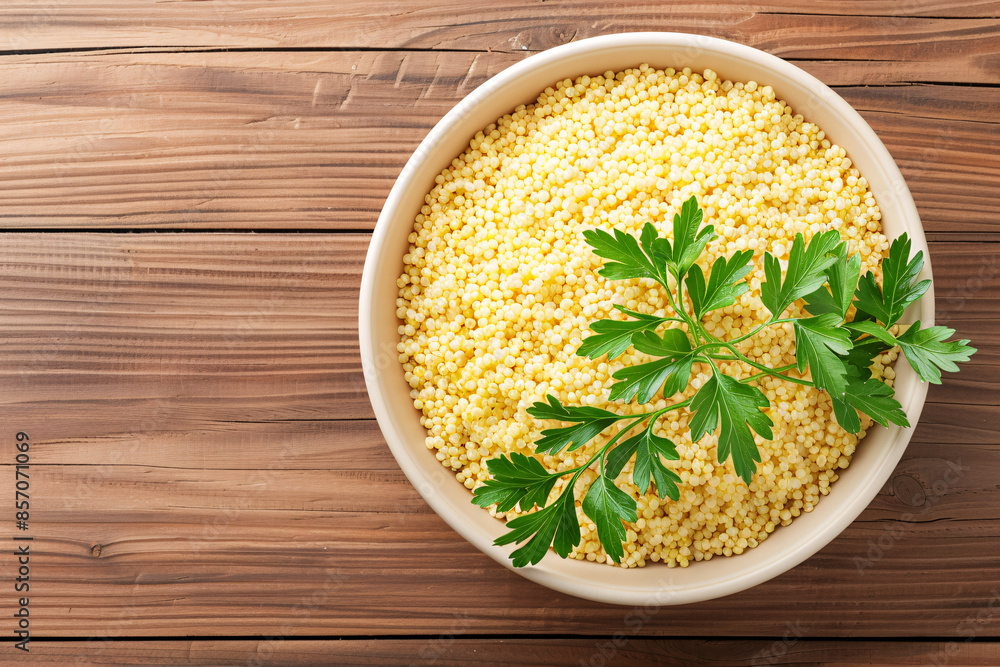A bowl of cooked rice with a sprig of parsley on top, set against a rustic wooden background. A bowl of cooked rice with a sprig of parsley on top, set against a rustic wooden background.