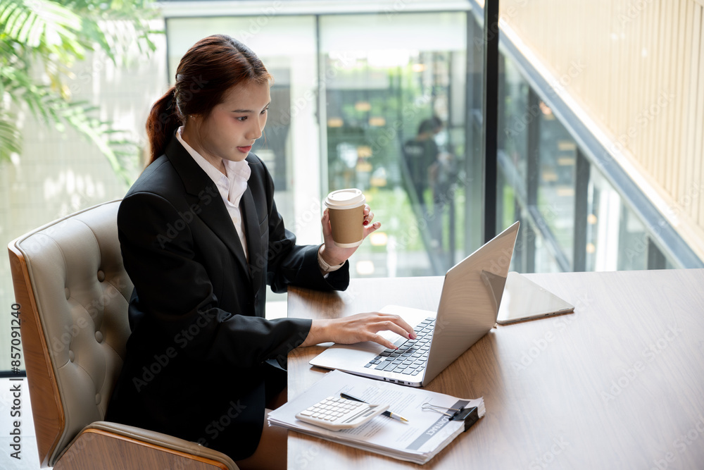 A beautiful young Asian businesswoman or female secretary working on her laptop computer in a office. businesspeople, technology A beautiful young Asian businesswoman or female secretary working on her laptop computer in a office. businesspeople, technology