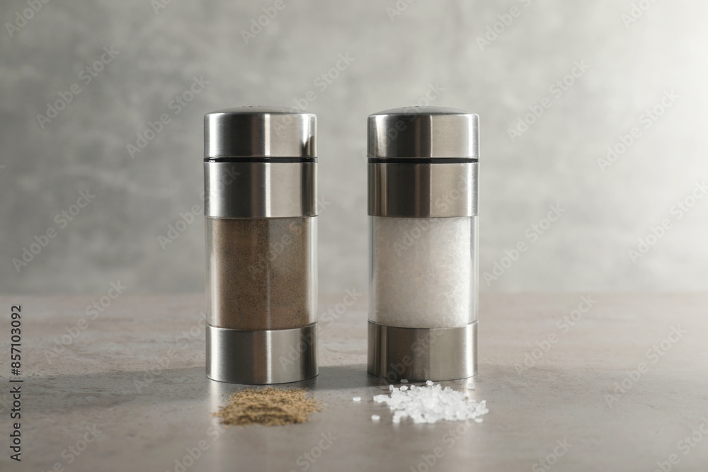 Salt and pepper shakers on grey textured table, closeup Salt and pepper shakers on grey textured table, closeup