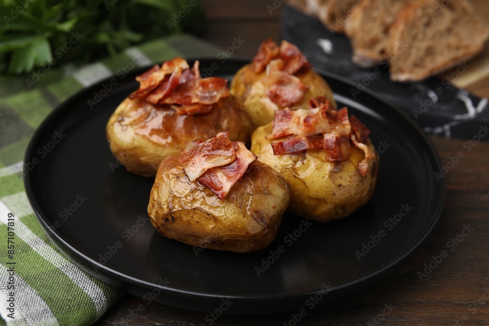 Delicious baked potatoes with bacon on wooden table, closeup