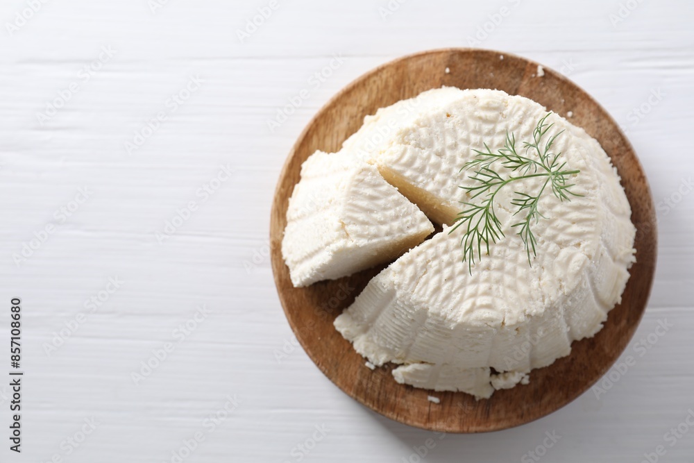 Fresh cut ricotta (cream cheese) with dill on white wooden table, top view. Space for text Fresh cut ricotta (cream cheese) with dill on white wooden table, top view. Space for text