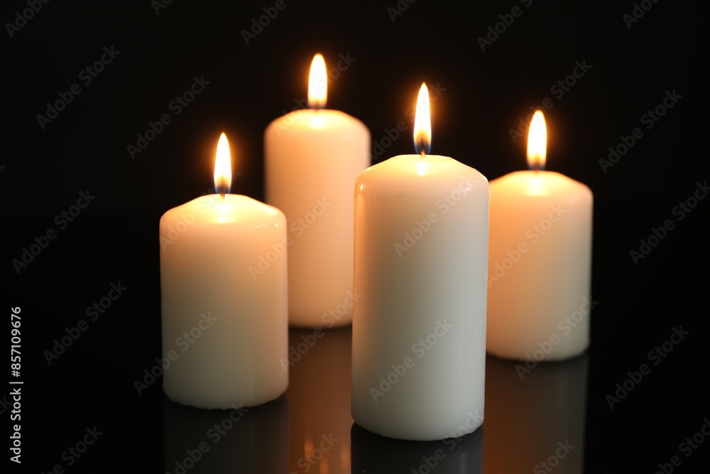 Many burning candles on mirror surface against black background Many burning candles on mirror surface against black background