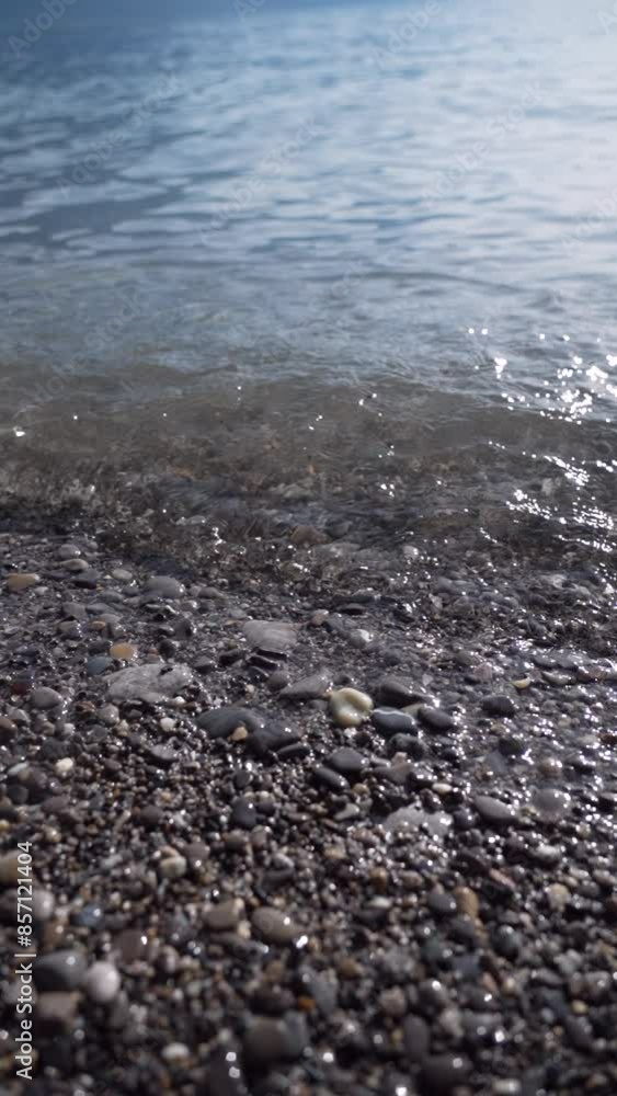 Stones Being Washed By Small Waves On The Shore Of A Peaceful Lake Under The Sun Stones Being Washed By Small Waves On The Shore Of A Peaceful Lake Under The Sun