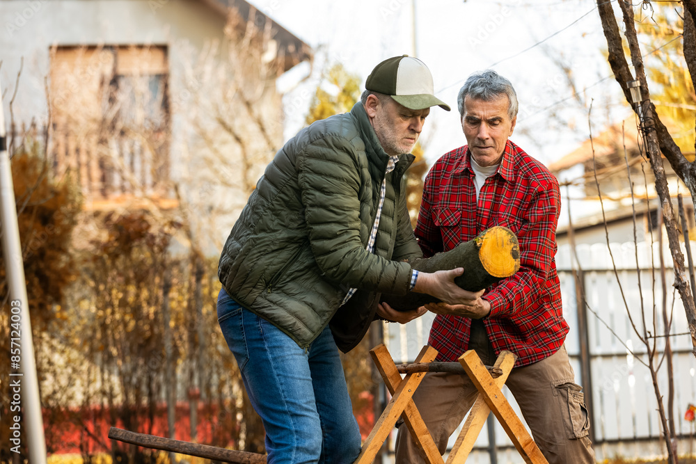 Two lumberjacks are setting up a piece of wood to be cut. Two lumberjacks are setting up a piece of wood to be cut.