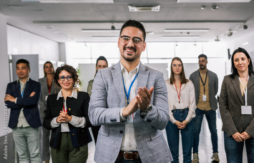 Obraz premium Portrait of man CEO standing in front of his multiracial colleagues and applauds.