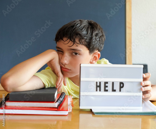 Photos pre-adolescent boy asking for help, overwhelmed by homework