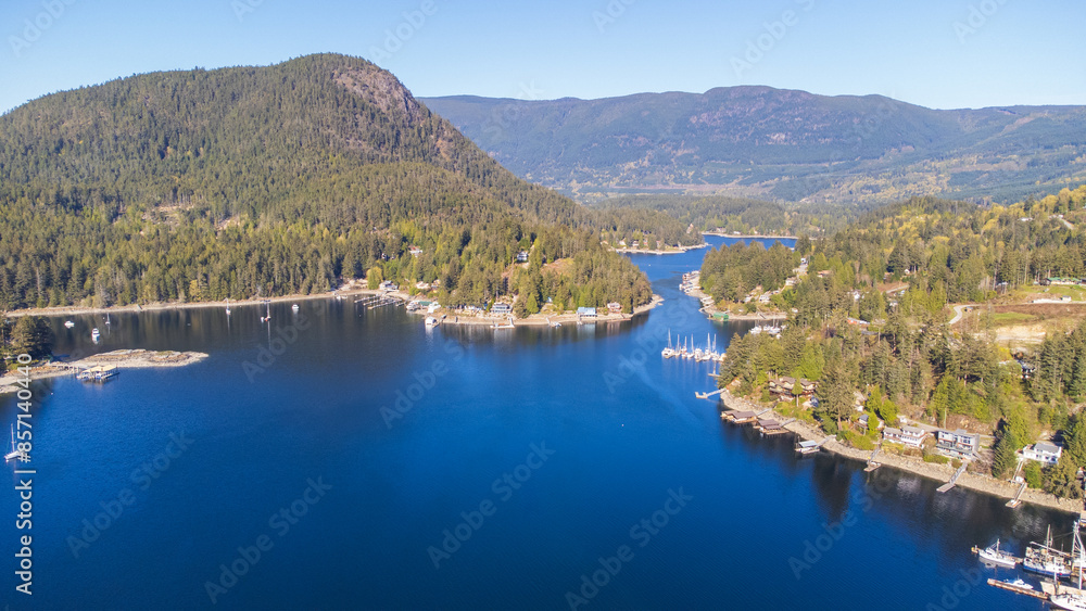 Naklejka premium Gerrans Bay on a sunny morning. Looking up a small inlet with mountains and forest surrounding the shoreline. Boats and homes dot the landscape.