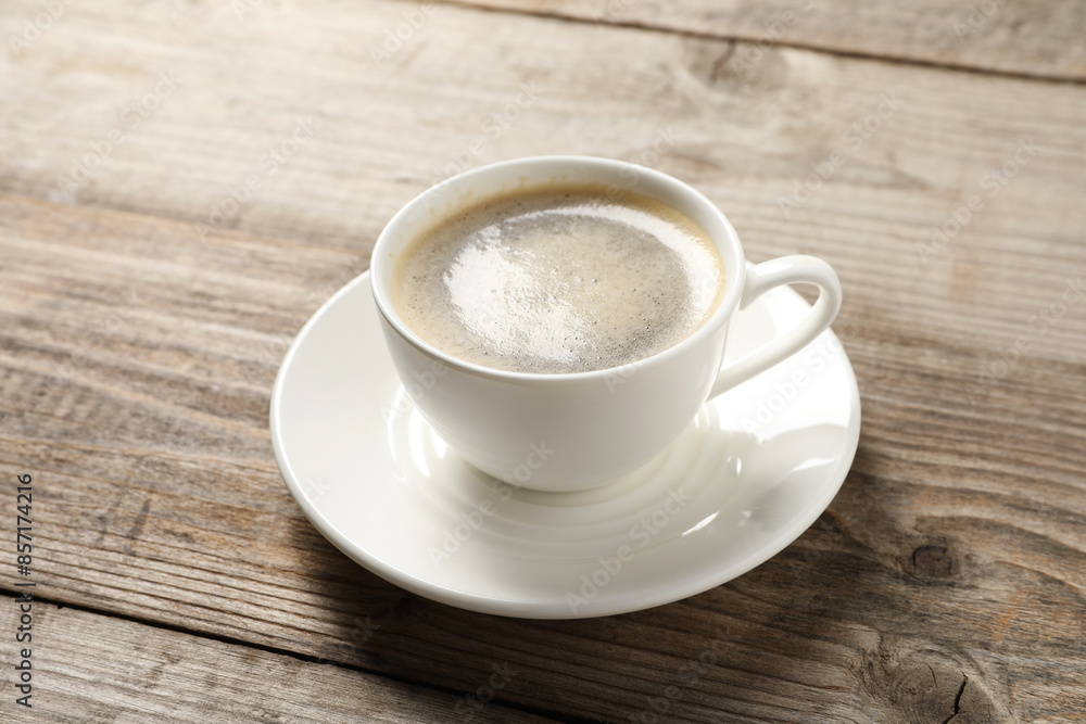 Tasty coffee in cup on wooden table, closeup Tasty coffee in cup on wooden table, closeup