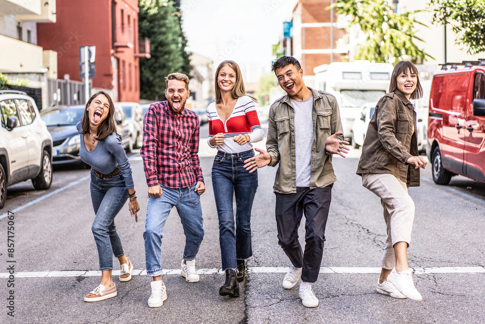 Obraz premium Group of friends having fun on the street. Five diverse young adults enjoying a day out and expressing happiness. Millennials showing friendship and joy.