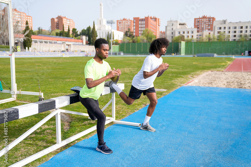 Two african men are stretching on a track