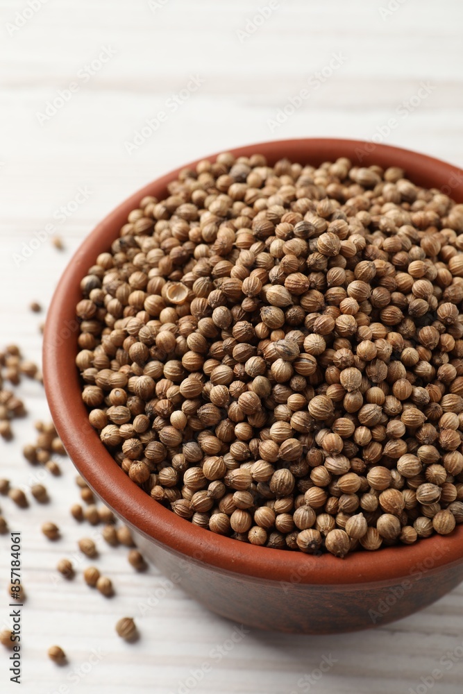 Dried coriander seeds in bowl on wooden table, closeup Dried coriander seeds in bowl on wooden table, closeup