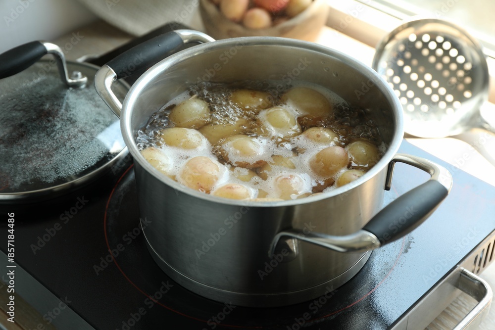 Boiling potatoes in pot on stove in kitchen Boiling potatoes in pot on stove in kitchen