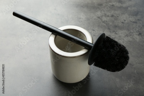 Toilet brush and holder on grey table