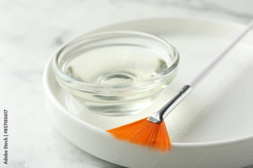Bowl of chemical peel and brush on white table, closeup. Peeling procedure Bowl of chemical peel and brush on white table, closeup. Peeling procedure
