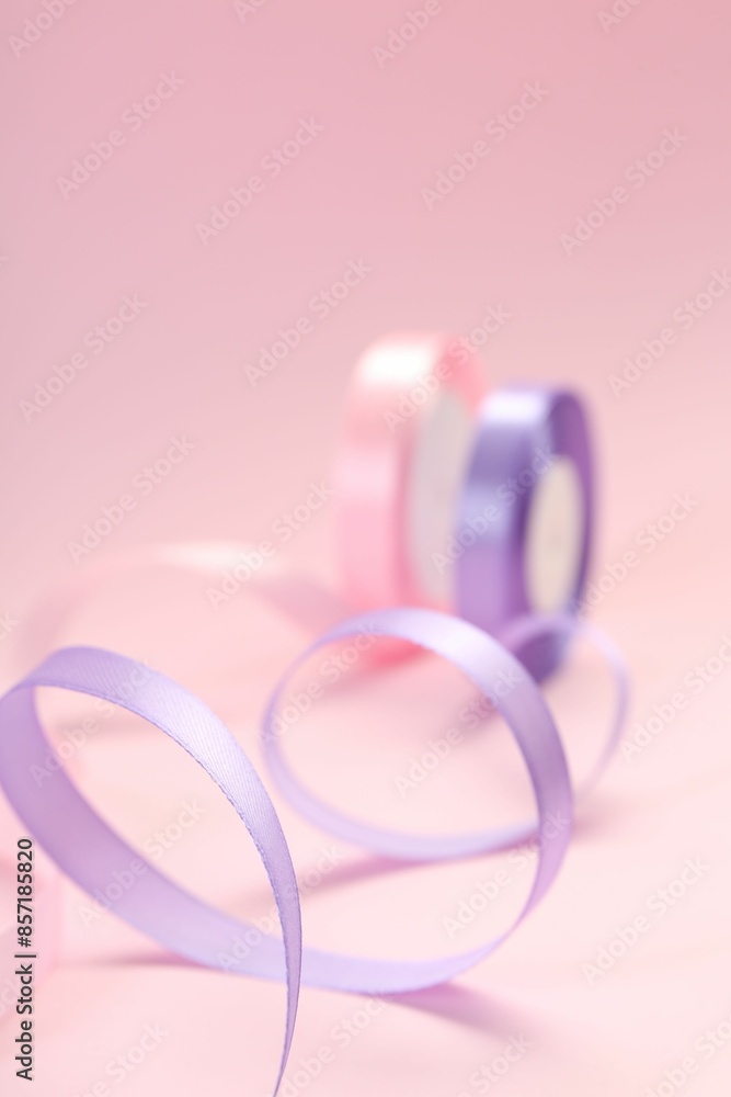 Ribbon reels in different colors on pink background, closeup view Ribbon reels in different colors on pink background, closeup view