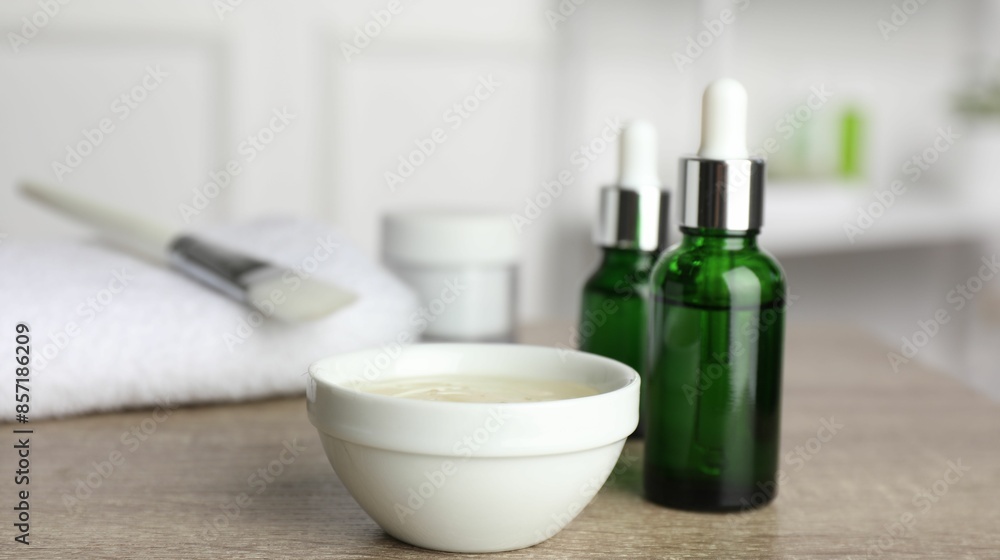 Peeling procedure. Bottles of chemical peel, bowl with liquid and brush on wooden table indoors. Space for text Peeling procedure. Bottles of chemical peel, bowl with liquid and brush on wooden table indoors. Space for text