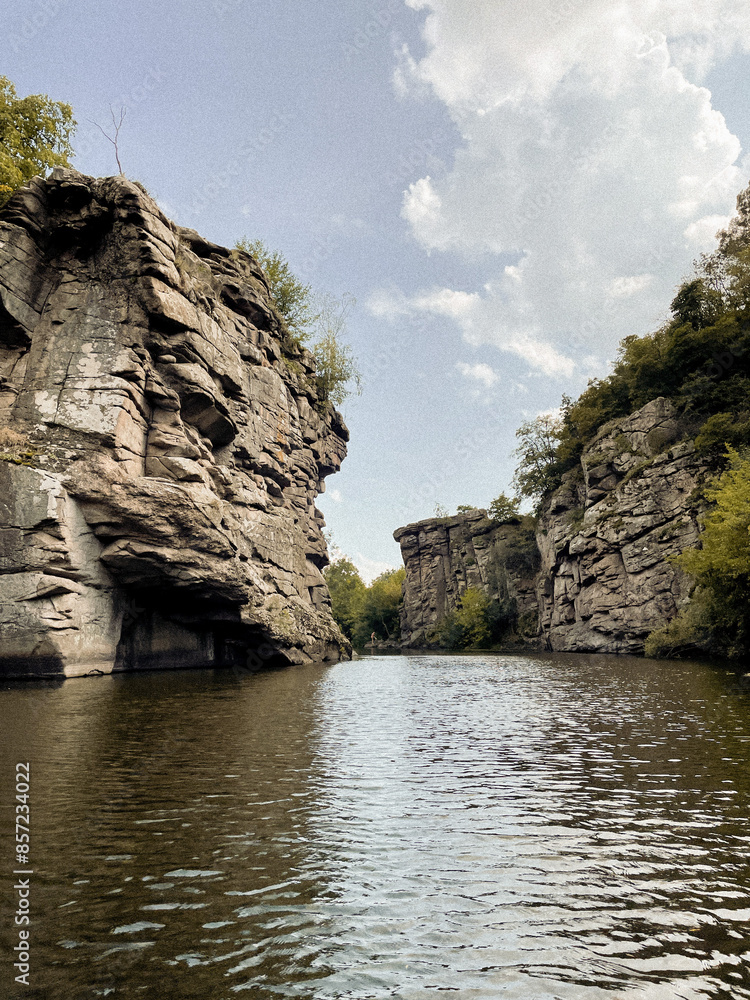Traveling along the mountain cliffs of a large canyon by boat in the middle of the lake. The beauty and tranquility of wild forests and green plants far from the city. Peace and relaxation Traveling along the mountain cliffs of a large canyon by boat in the middle of the lake. The beauty and tranquility of wild forests and green plants far from the city. Peace and relaxation