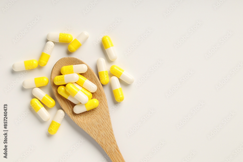 Antibiotic pills and spoon on white background, top view. Space for text Antibiotic pills and spoon on white background, top view. Space for text