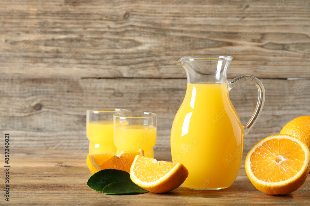 Tasty orange juice, fresh fruits and green leaf on wooden table Tasty orange juice, fresh fruits and green leaf on wooden table