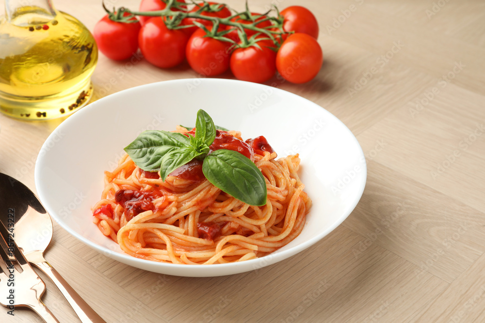 Delicious pasta with tomato sauce and basil in bowl on wooden table Delicious pasta with tomato sauce and basil in bowl on wooden table