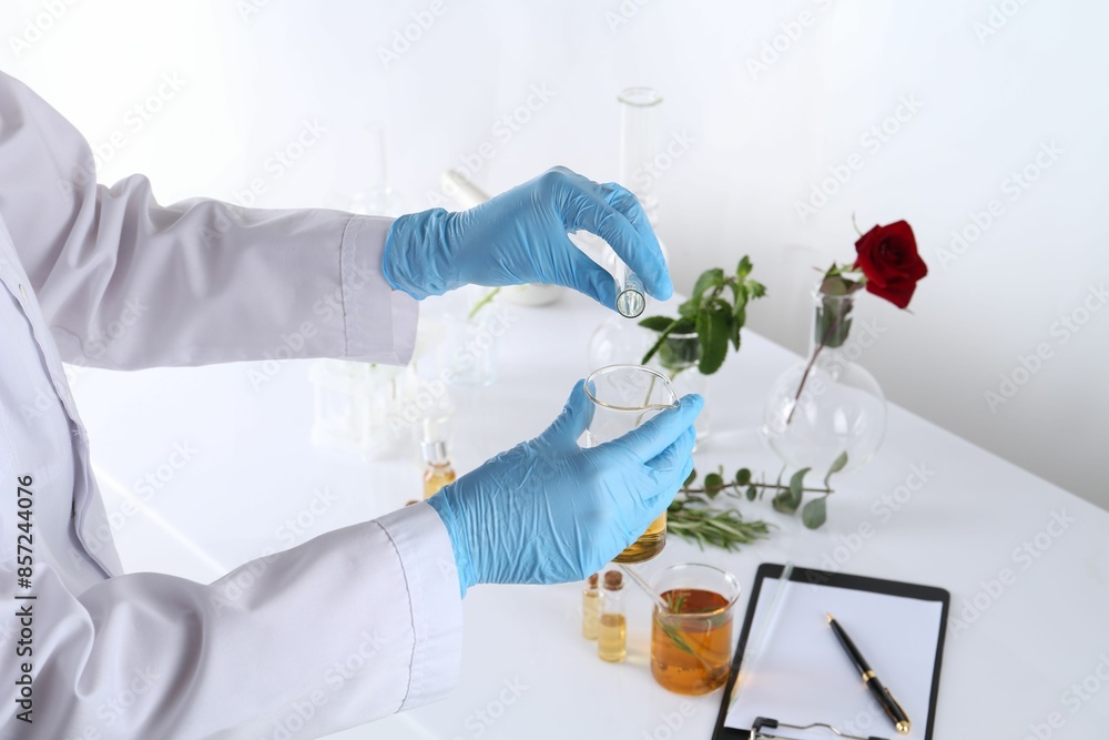 Aromatherapy product. Scientist developing essential oils at white table in laboratory, closeup Aromatherapy product. Scientist developing essential oils at white table in laboratory, closeup