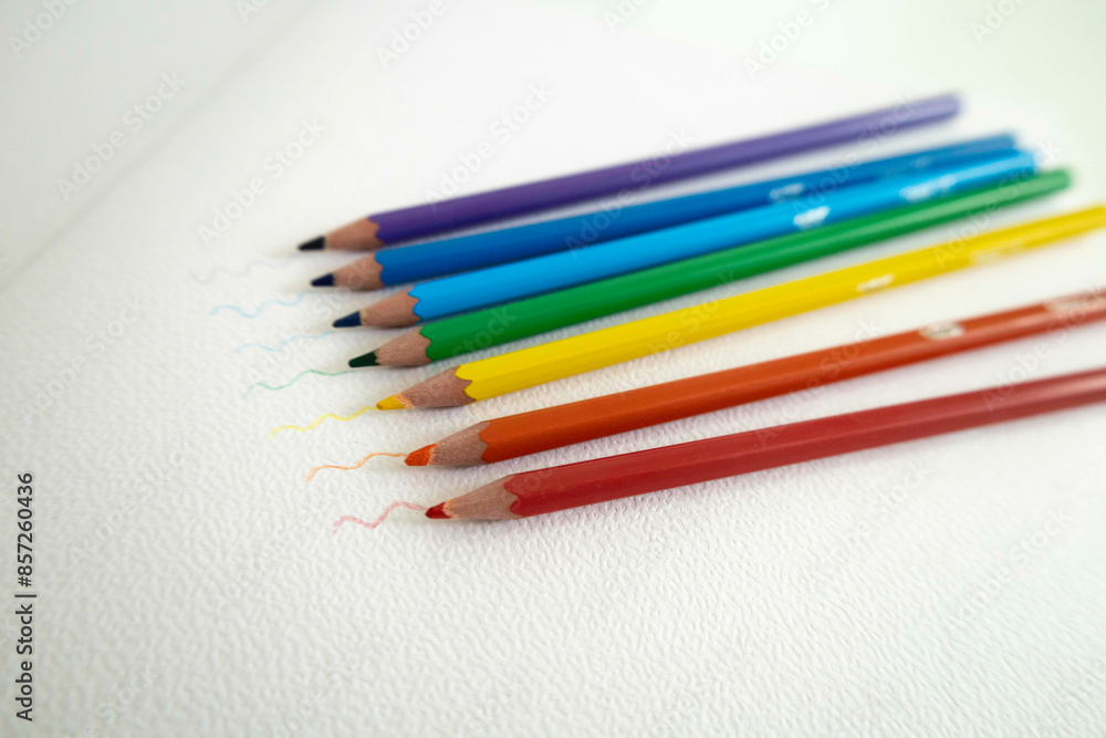 Pencils in rainbow colors on a white sheet Pencils in rainbow colors on a white sheet
