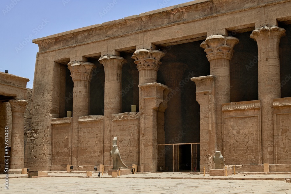 Fototapeta premium Ancient Temple of Horus with statues and tall columns under a clear blue sky in Egypt.