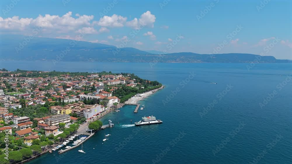 Stunning aerial drone view of Lake Garda's blue waters and shoreline on a bright summer day. Stunning aerial drone view of Lake Garda's blue waters and shoreline on a bright summer day.
