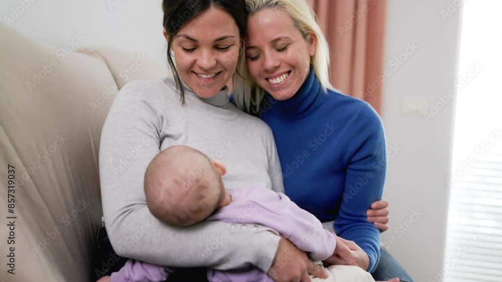 Gay lesbian couple with child baby at home. Happy LGBT family having tender moment together Gay lesbian couple with child baby at home. Happy LGBT family having tender moment together