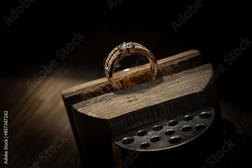 Put diamond gem ring. diamond ring production. hand made in craftsman workshop close up. black background.