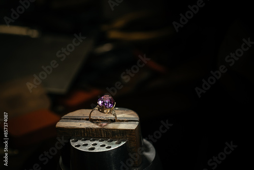 golden ring on jeweller workplace and profession tools against a dark background with copy space, selected focus, narrow depth of field