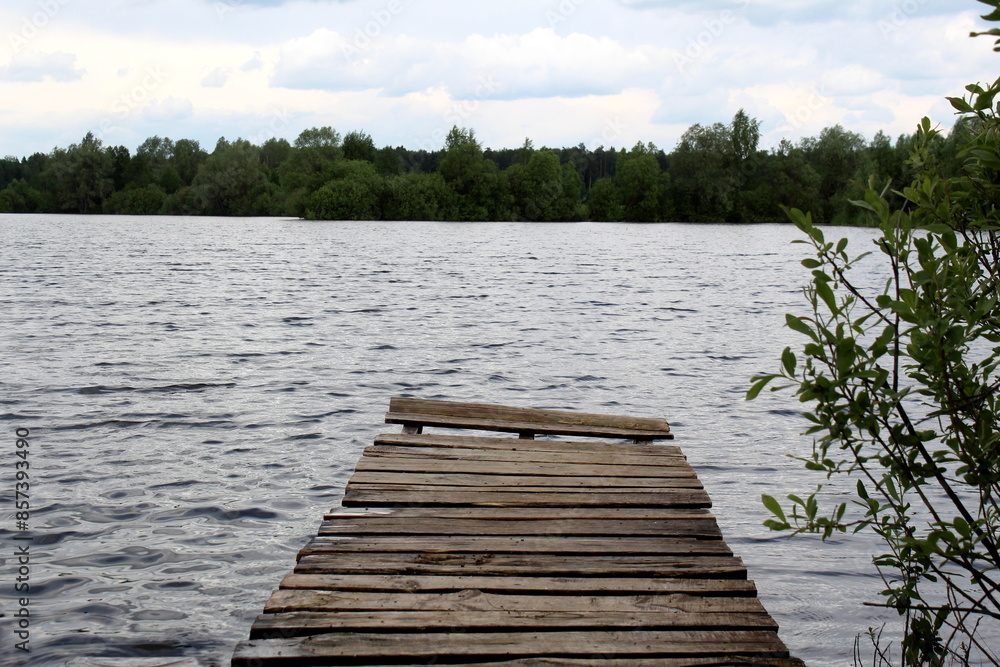 Fototapeta premium Wooden bridge near the lake shore.