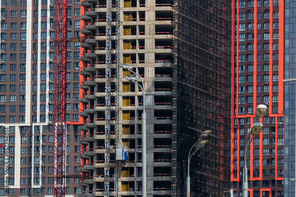 Close-up side view of multi coloured wall of modern skyscraper building under construction. Copy space. Abstract construction background. Housing development theme. Close-up side view of multi coloured wall of modern skyscraper building under construction. Copy space. Abstract construction background. Housing development theme.