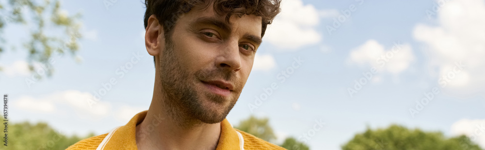 Obraz premium A man in a yellow shirt stares at the camera, his expression intense and captivating.