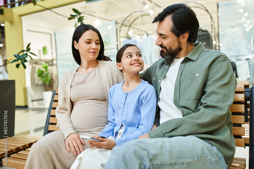 A joyful family sits on a bench in a bustling shopping mall, taking a break during their shopping weekend.