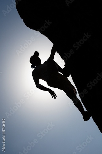 rock climbing boy wearing cap silhouette 