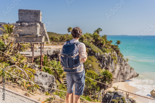 Obraz na płótnie Man tourist enjoying the view Pre-Columbian Mayan walled city of Tulum, Quintana Roo, Mexico, North America, Tulum, Mexico. El Castillo - castle the Mayan city of Tulum main temple w salonie