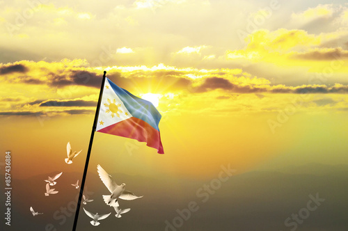 Philippines flag waving with flying doves against sunset or sunrise. Philippines flag for Republic Day and Independence Day.