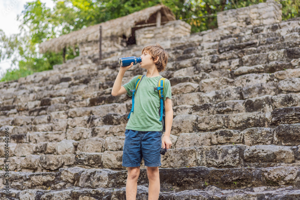Boy tourist at Coba, Mexico. Ancient mayan city in Mexico. Coba is an archaeological area and a famous landmark of Yucatan Peninsula. Cloudy sky over a pyramid in Mexico Boy tourist at Coba, Mexico. Ancient mayan city in Mexico. Coba is an archaeological area and a famous landmark of Yucatan Peninsula. Cloudy sky over a pyramid in Mexico