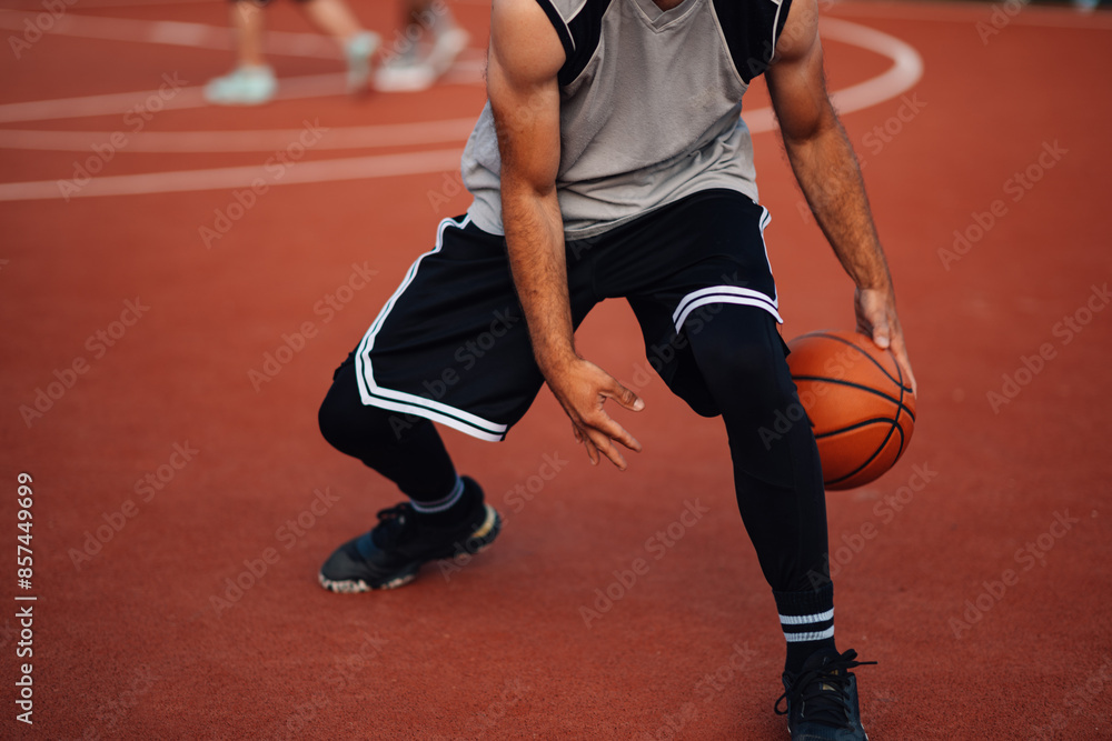 Fototapeta premium Athlete dribbling a basketball on court