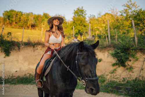 Portrait of smiling horsewoman horseback riding a horse at homestead.