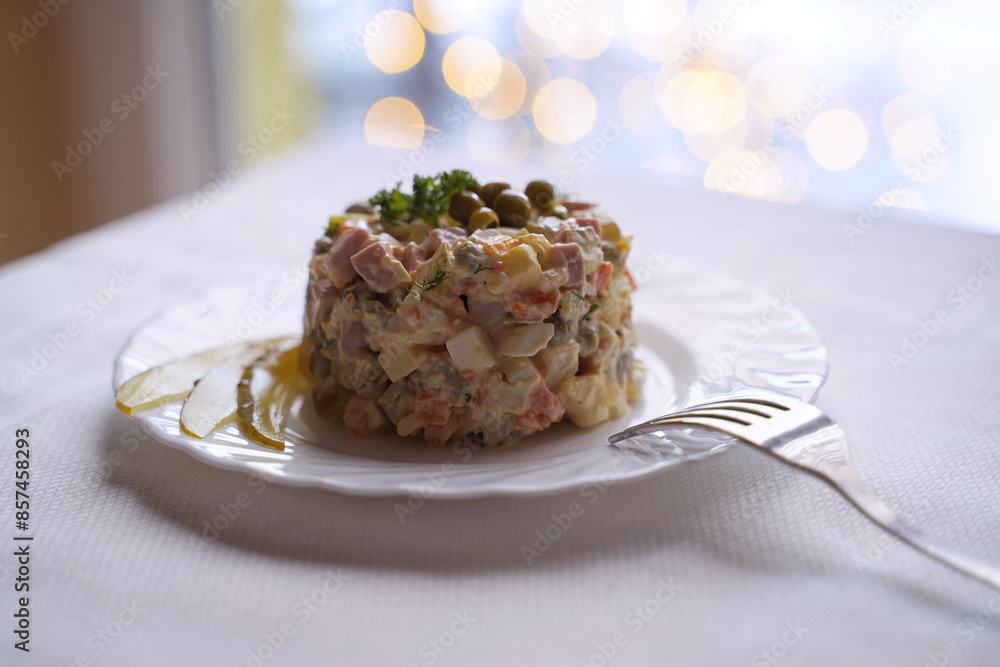 Olivier salad, traditional salad dish of post Soviet cuisine. Traditional Ukrainian food on the table with embroidered tablecloth.