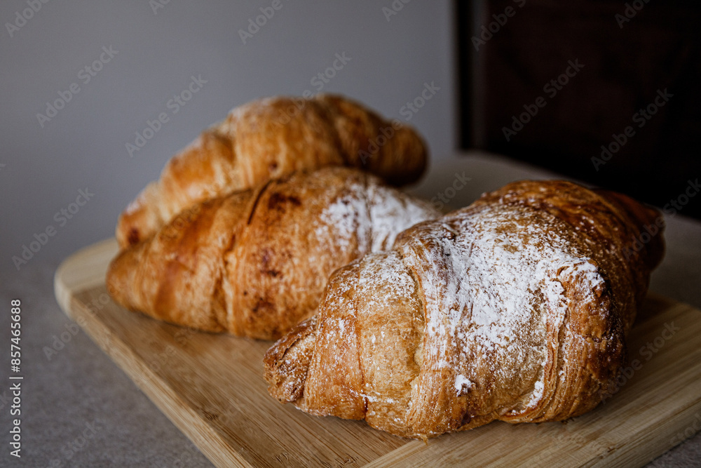 Crispy, fresh, homemade, oven-baked French croissant on a wooden plate; lots of croissants; coffee time; snack; cheat meal Crispy, fresh, homemade, oven-baked French croissant on a wooden plate; lots of croissants; coffee time; snack; cheat meal