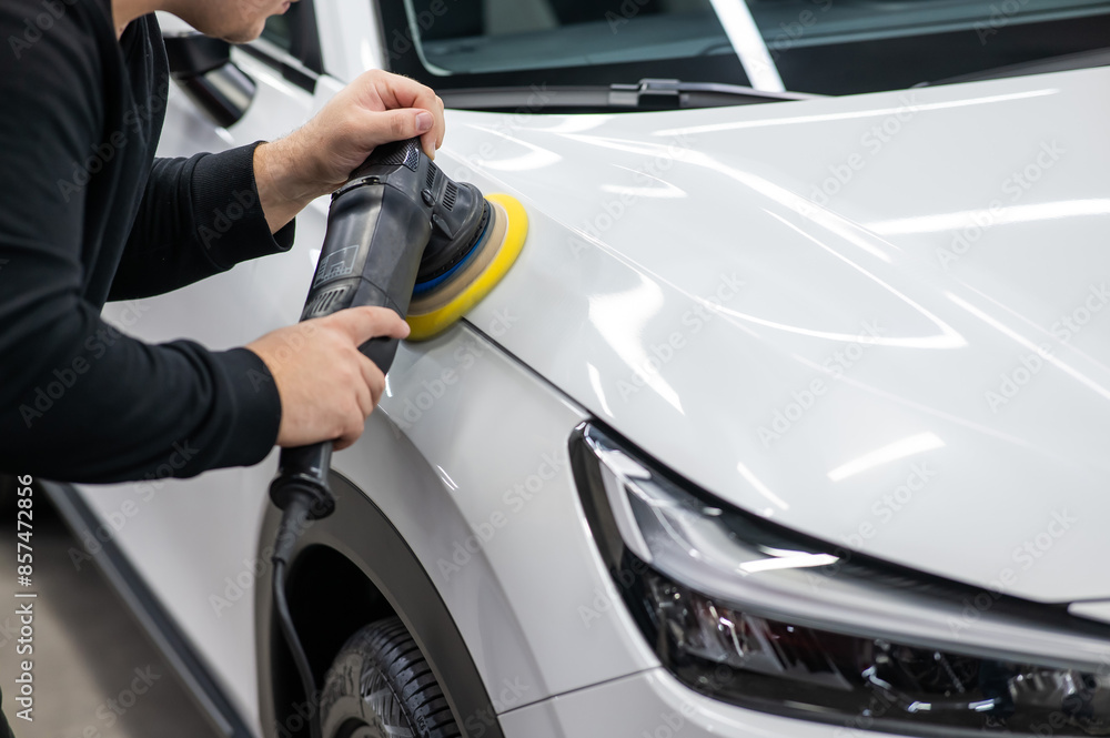 Process of polishing white car hood surface using orbital polishing machine. Process of polishing white car hood surface using orbital polishing machine.