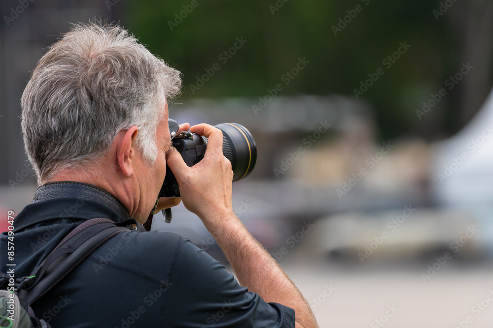 A tourist takes photos with his camera in the city A tourist takes photos with his camera in the city