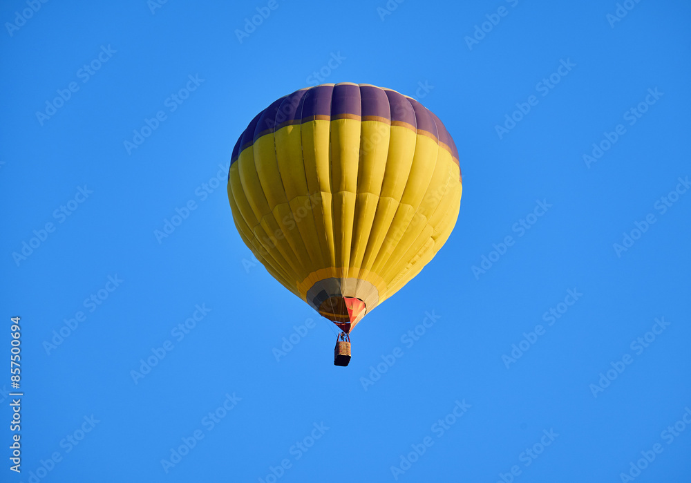 A vibrant yellow hot air balloon floats gracefully in a clear blue sky, offering a sense of adventure and freedom. A vibrant yellow hot air balloon floats gracefully in a clear blue sky, offering a sense of adventure and freedom.