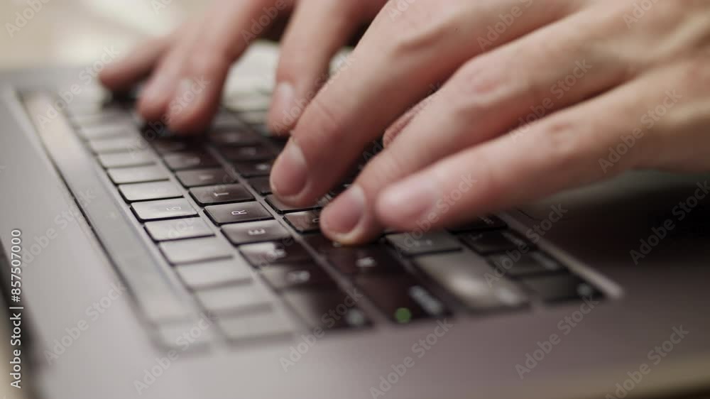 Close-up slow-motion video of a person typing something on the laptop.